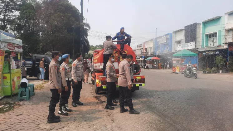 Polsek Tigaraksa Bersama Damkar Semprot Jalan Terdampak Abu Vulkanik