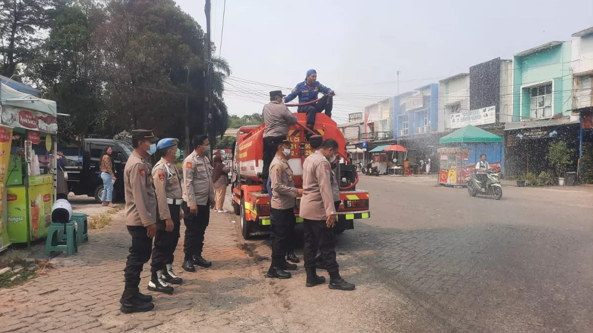 Polsek Tigaraksa Bersama Damkar Semprot Jalan Terdampak Abu Vulkanik