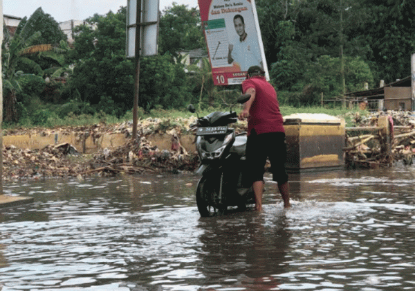 Momen Warga Cipayung Manfaatkan Air Banjir untuk Cuci Motor dan Memancing