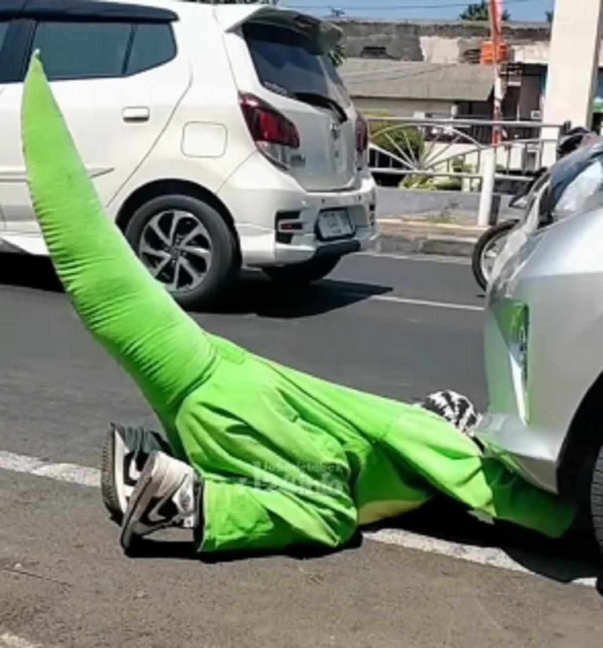 Momen Seorang Pria Berkostum Dinosaurus Bantu Pengendara Wanita yang Alami Kempes Ban Mobil, Begini Cara Ganti Ban